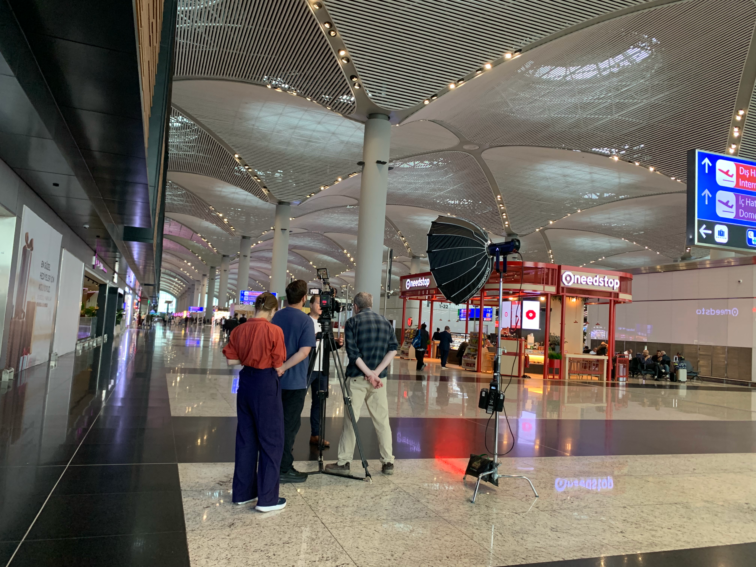 Camera crew filming beneath the vaulted terminal roof at Istanbul Airport
