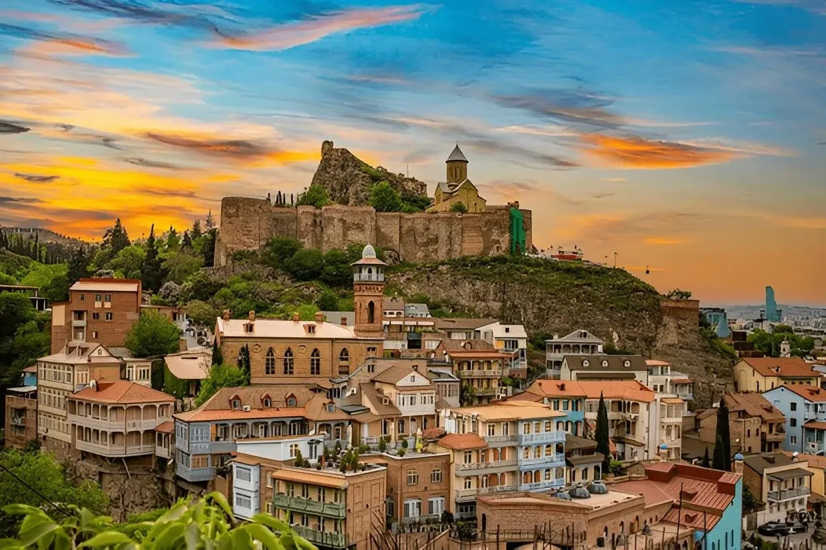 Tbilisi Old Town houses below Narikala Fortress at sunset